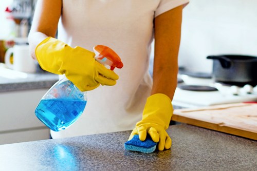 A professional technician cleaning upholstery in a modern living room.